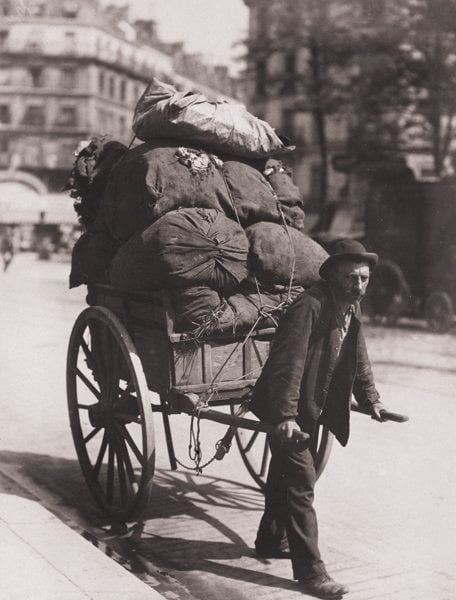 Old man carrying wooden trailer