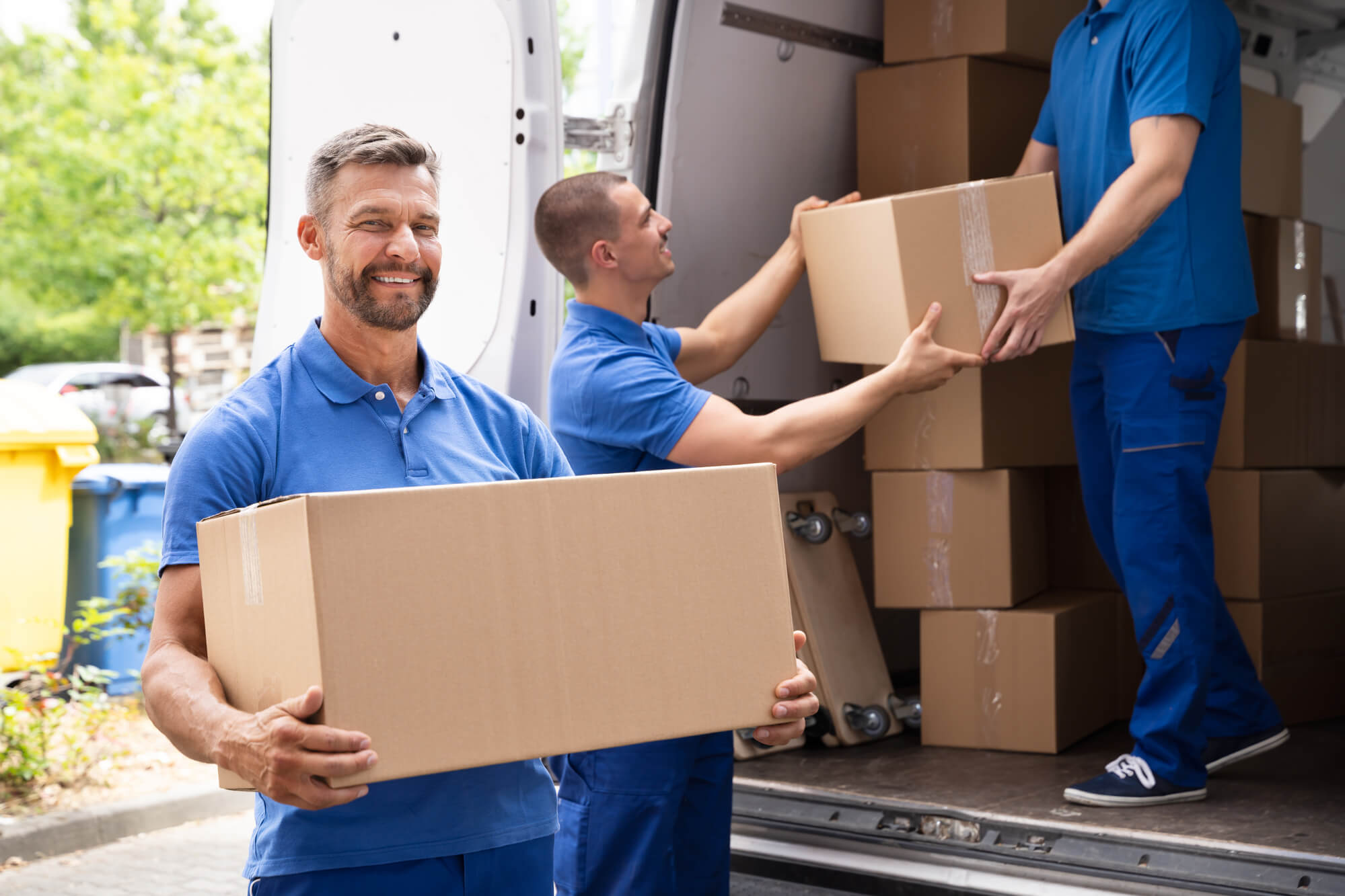 Movers carry box out of van