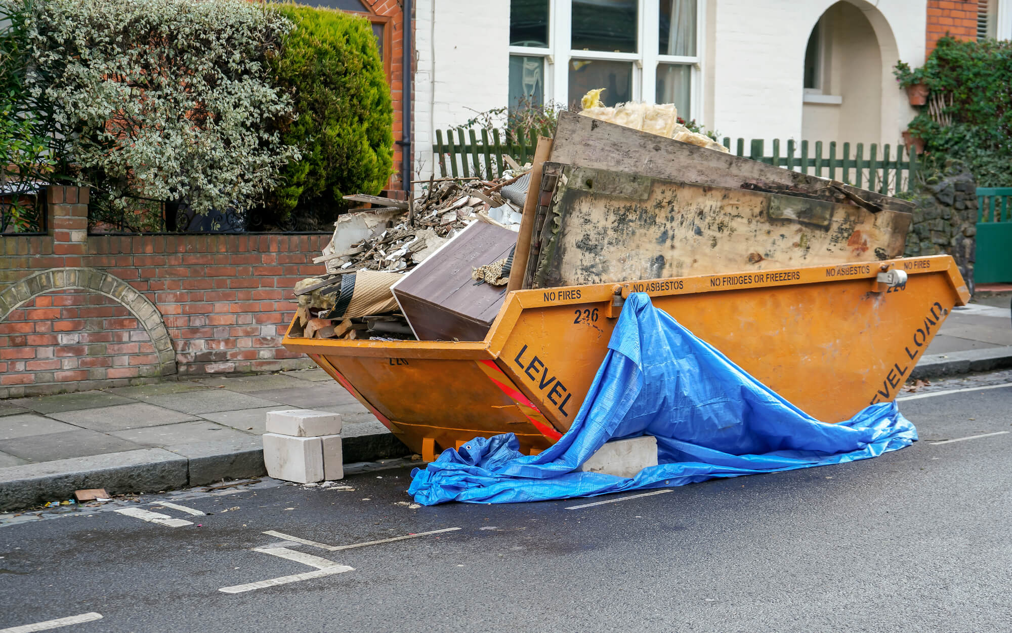 orange skip container full of building materials