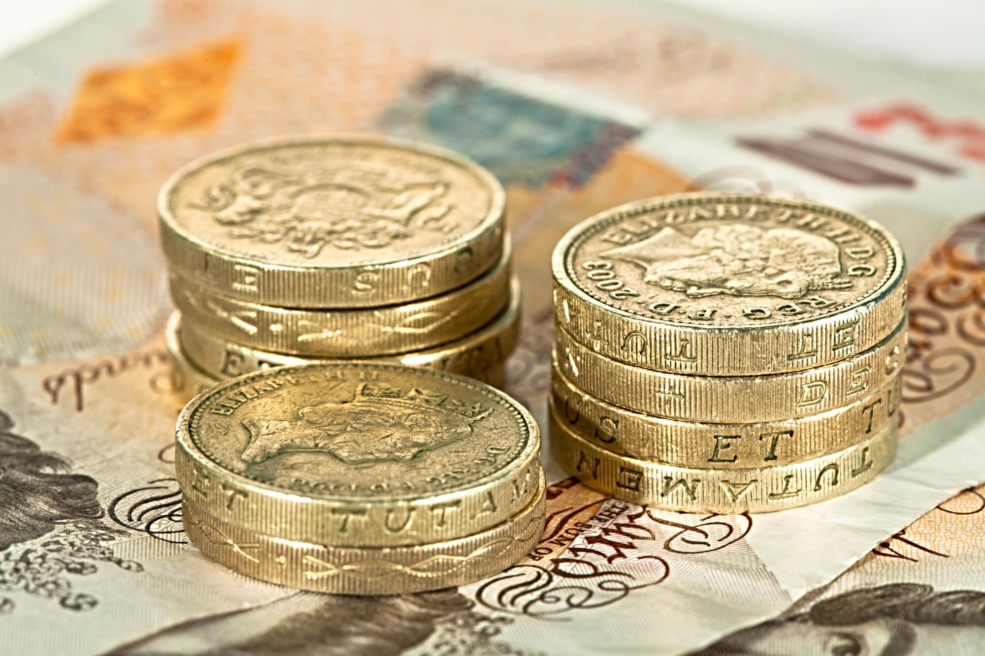 Pound coins placed on 10 pound notes